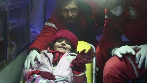 A critically ill Syrian girl waves as she is evacuated from the Eastern Ghouta
