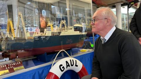 Kevin Tracey, brother of Billy Tracey who was lost on the Gaul, examines a model of the ship