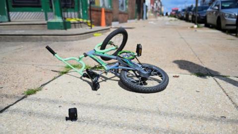 Image shows a child's bicycle at the scene of the shooting