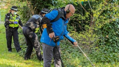 Mike Morton searching for weapons alongside police officers