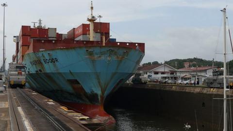 A cargo ship passing through the Panama Canal