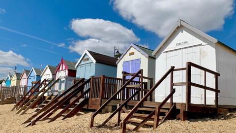 Beach huts in Felixstowe with blue skies and cumulus clouds overhead. Picture by BBC Weather Watcher Walking Tractor