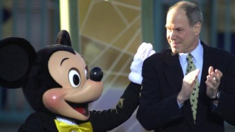 Michael Eisner, CEO and chairman of the Walt Disney Company, gets a pat on the back from Mickey Mouse in 2001