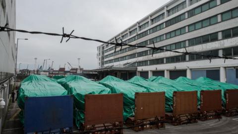 Armoured vehicles belonging to the Singapore military are seen covered with tarpaulin at a customs facility in Hong Kong