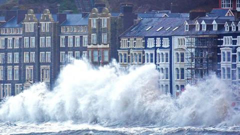 Storm Eunice and rough seas bring huge crashing waves along Aberystwyth promenade in Ceredigion, Wales