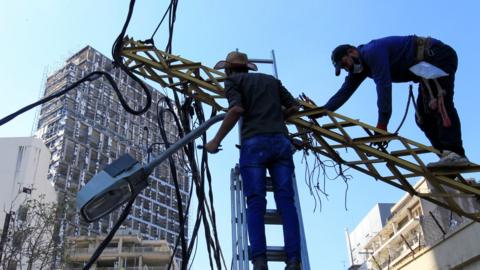 Workers dismantle damaged cables in Beirut's port area