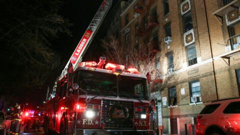 Fire department personnel work on the scene of an apartment fire in Bronx, New York, December 28, 2017