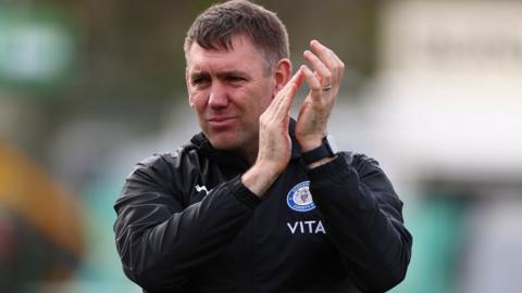Dave Challinor, manager of Stockport County, applauds fans at full-time