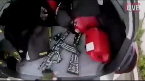 Grab from live stream shows gunman retrieving weapons from boot of car, Christchurch, NZ (15 March)