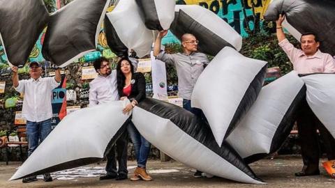 Protesters holding inflatable to represent social leaders killed so far in 2017