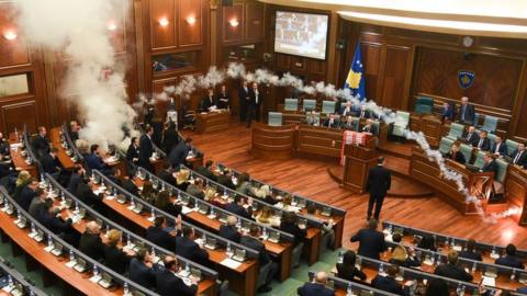 Kosovo's opposition lawmakers release a teargas canister inside the country's parliament in Pristina on 21 March 2018