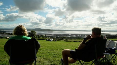 A couple on a pop-up campsite overlooking Morecambe Bay