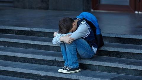 Young boy cries on steps