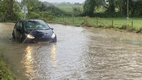 Car in flooded road in Flowton