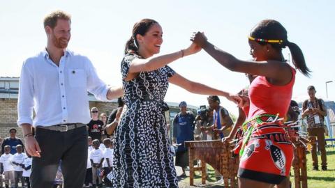 Harry and Meghan dance after arriving in Africa