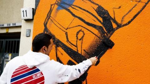 The artist Deih works on his street art painting on the outskirts of a residential house in Berlin (15 September 2017)