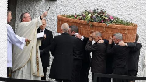 Priest Father John Joe Duffy blesses the coffin of Jessica Gallagher