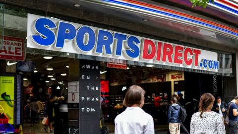 Shoppers passing a Sports Direct shop