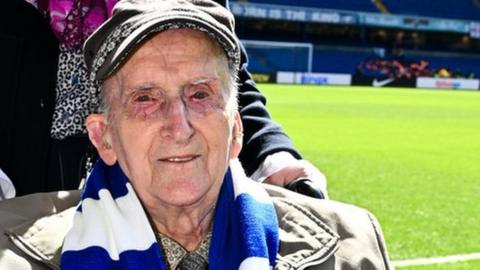 Alf Wells holding a Chelsea football shirt bearing his name