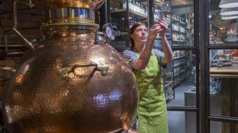 A woman working in a gin distillery