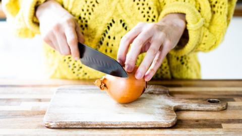 Someone chopping an onion