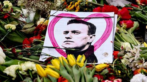 Picture of Navalny on top of floral tributes