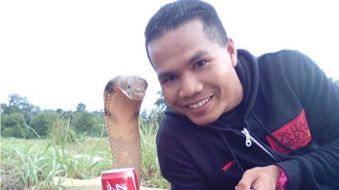 Abu Zarin Husin takes a selfie with one of his snakes