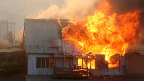 A house burns following the spread of wildfires in Valparaiso, Chile, December 24, 2019.