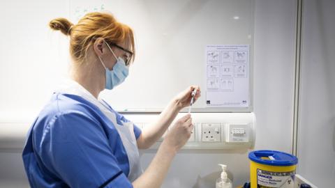 Nurse Eleanor Pinkerton prepares a coronavirus vaccine to be given to a health and care staff member at the NHS Louisa Jordan Hospital in Glasgow, as part of a mass vaccination drive by NHS Greater Glasgow and Clyde. Picture date: Saturday January 23, 2021.