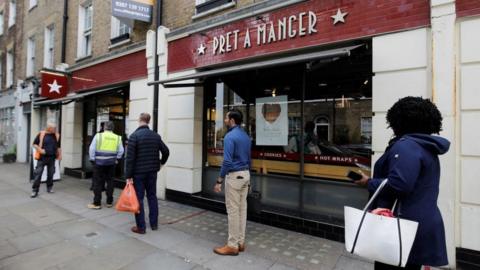 People queue outside a Pret A Manger shop in London