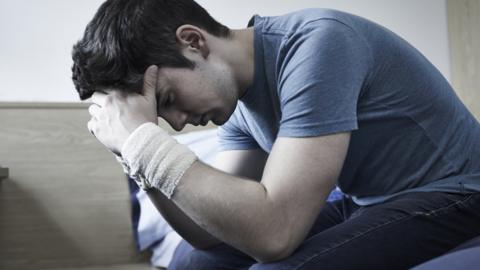 Young person with their head in their hands