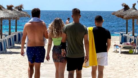 Tourists arrive at Magaluf Beach in Calvia, on the Balearic Island of Mallorca, on 28 June 2021