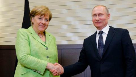 Merkel shakes hands with Putin