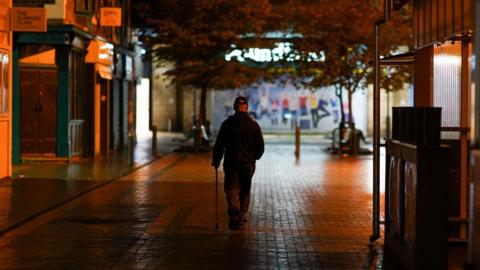 A man walking through Middlesbrough town centre at night