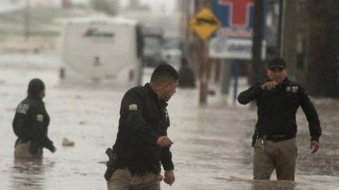 Police officers wade through severe floods, caused by heavy rains, affecting the city of Saltillo in the northern state of Coahuila, Mexico 26 July 2020