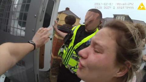 Minnie is taken into the police van