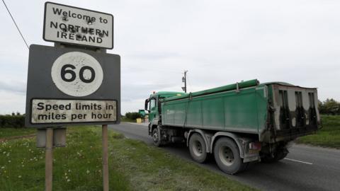 A lorry driving past a sign that reads: Welcome to Northern Ireland