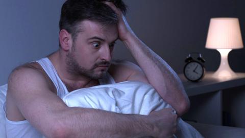 Man waking up early in the morning looking stressed