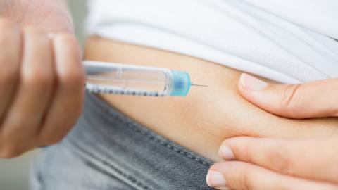 girl with diabetes injecting insulin