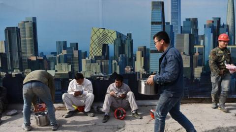 Construction workers against backdrop of Beijing skyline
