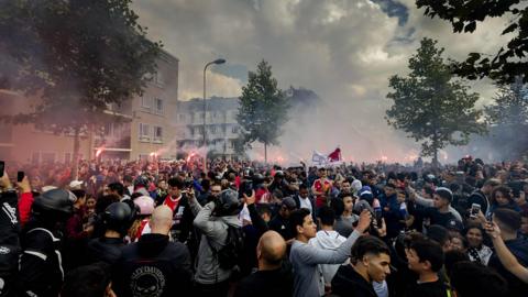 Ajax fans gather outside of the family home of Dutch midfielder Abdelhak Nouri on July 14, 2017 in Amsterdam