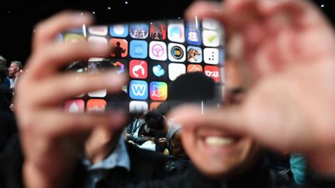 A man takes a photo before the start of Apple"s Worldwide Developer Conference (WWDC) at the San Jose Convention Centerin San Jose, California on June 4, 2018.