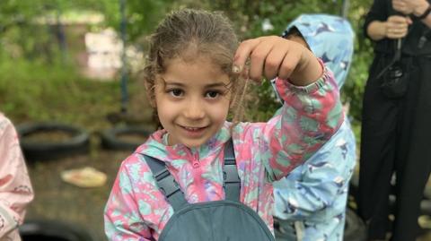 Girl with worm at nursery