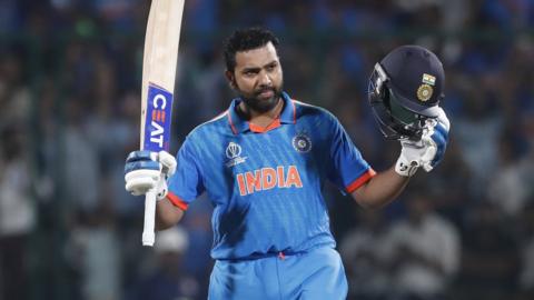 India captain Rohit Sharma raises his bat and helmet after reaching a century