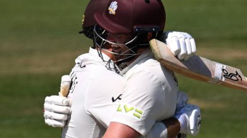 Dom Sibley celebrates his 100 with Surrey team-mate Ben Foakes