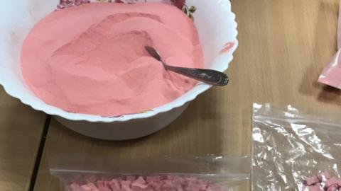 Pink powder and tablets displayed as the result of a police raid