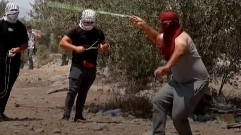 Protester wearing a mask throwing rocks