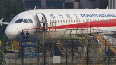 Workers inspect a Sichuan Airlines aircraft that made an emergency landing after a windshield on the cockpit broke off, at an airport in Chengdu, Sichuan province, China May 14, 2018.