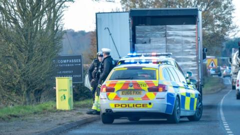 Police officers guard the lorry