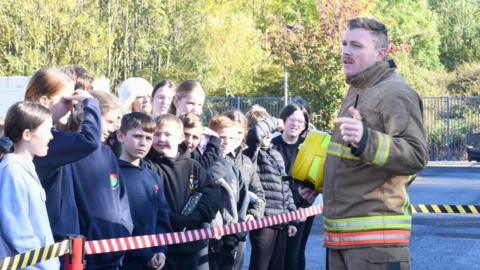Ryan Young giving a safety lesson to schoolchildren in his role with Tyne and Wear Fire and Rescue Service